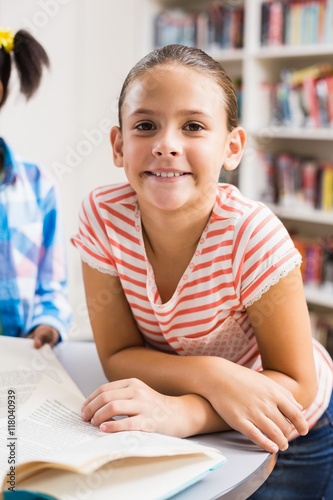 Schoolgirl reading a book in library