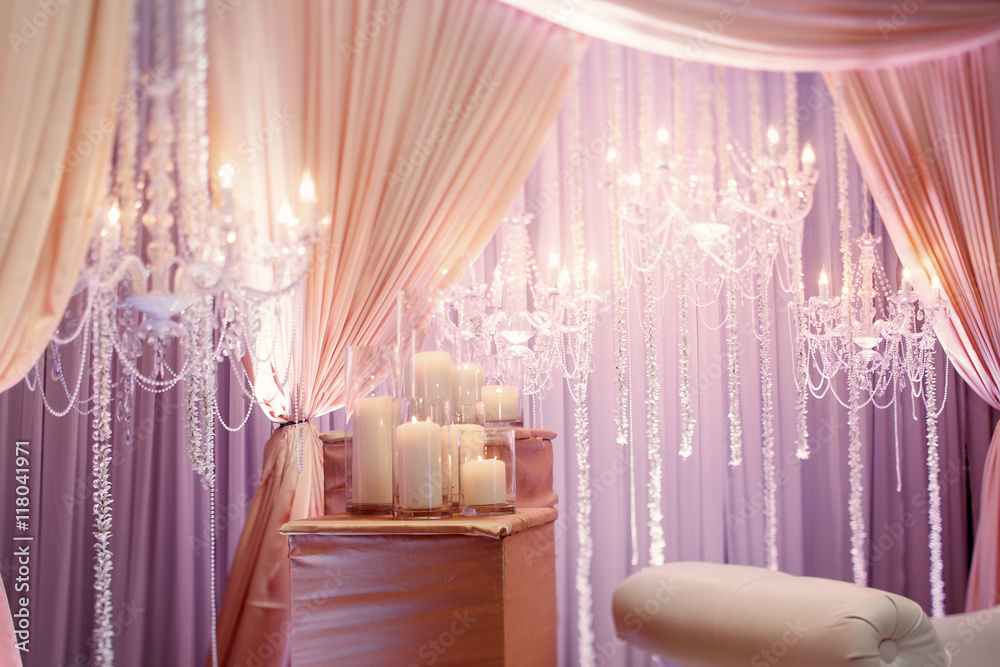 Tables covered with silk cloth and served with white candles sta