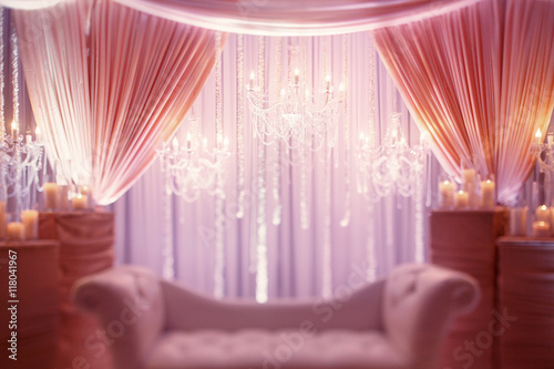 Luxury white couch stands under the crystal chandeliers in a pin photo