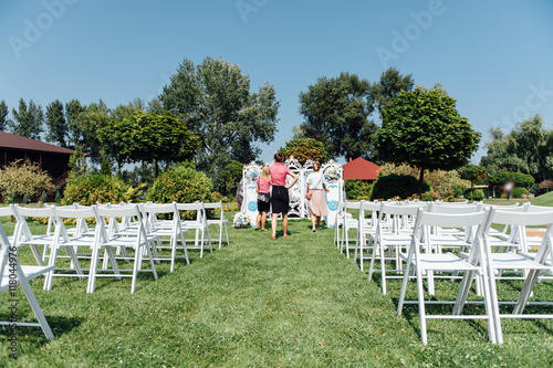 Rows of white folding chairs on lawn