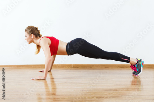 Attractive fit girl doing physical exercises at gym