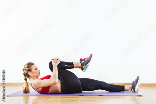 Attractive fit girl doing physical exercises at gym