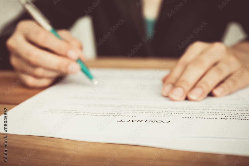 Businesswoman's hand with pen completing personal information on Businesswoman's hand with pen completing personal information on