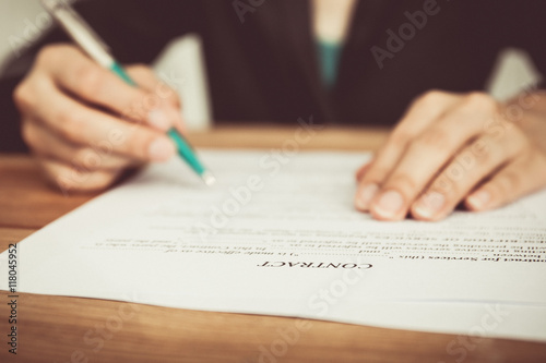 Businesswoman's hand with pen completing personal information on