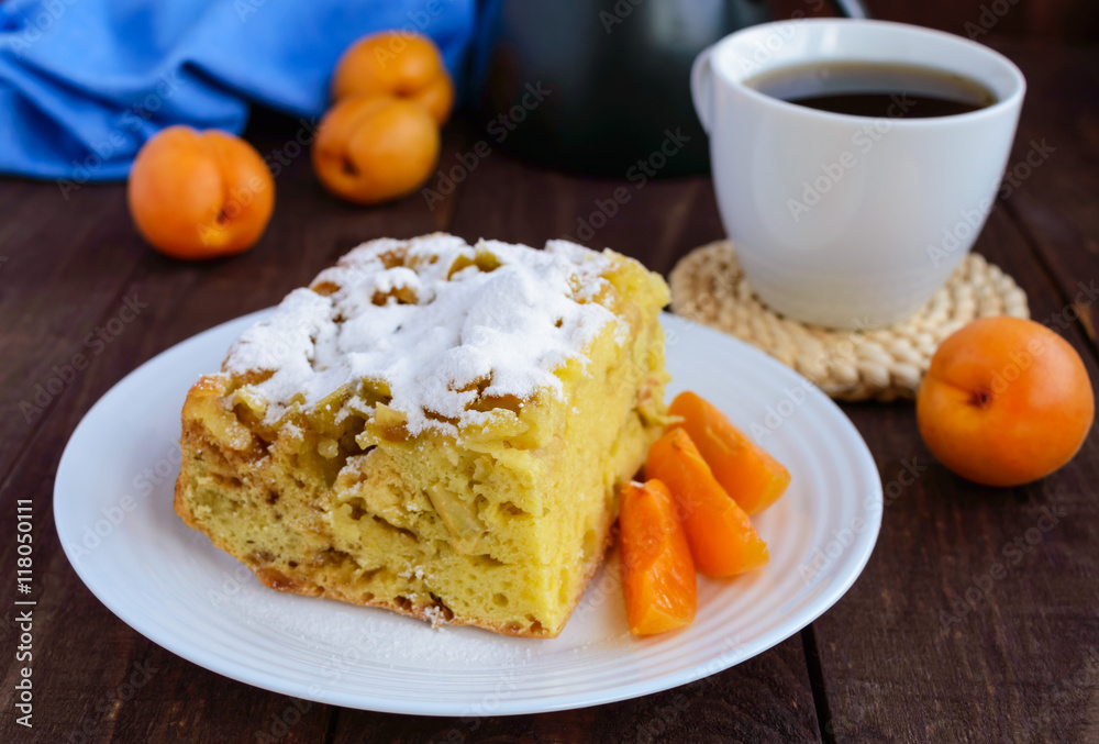 A piece of homemade cake with slices of apple and apricot, decorative powdered sugar. A piece of homemade cake with slices of apple and apricot, decorative powdered sugar.