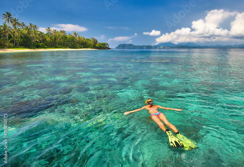 woman snorkelling in tropical waters near island