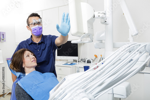 Dentist Explaining Xray To Female Patient In Clinic