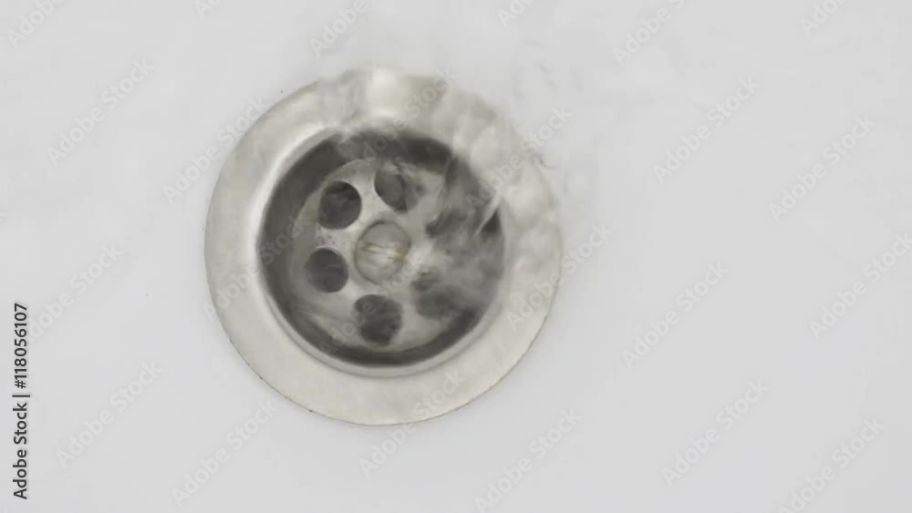 Water stream going down the drain. Water stream going down the drain.