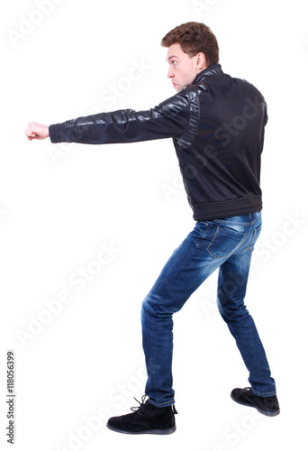 back view of guy funny fights waving his arms and legs. Isolated over white background. Rear view people collection. backside view of person. Curly guy in a black leather jacket fun waving his arms. 