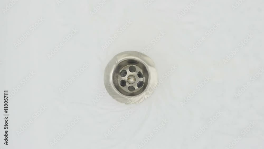 Streaming water in sink. Water stream going down the drain. Streaming water in sink. Water stream going down the drain.