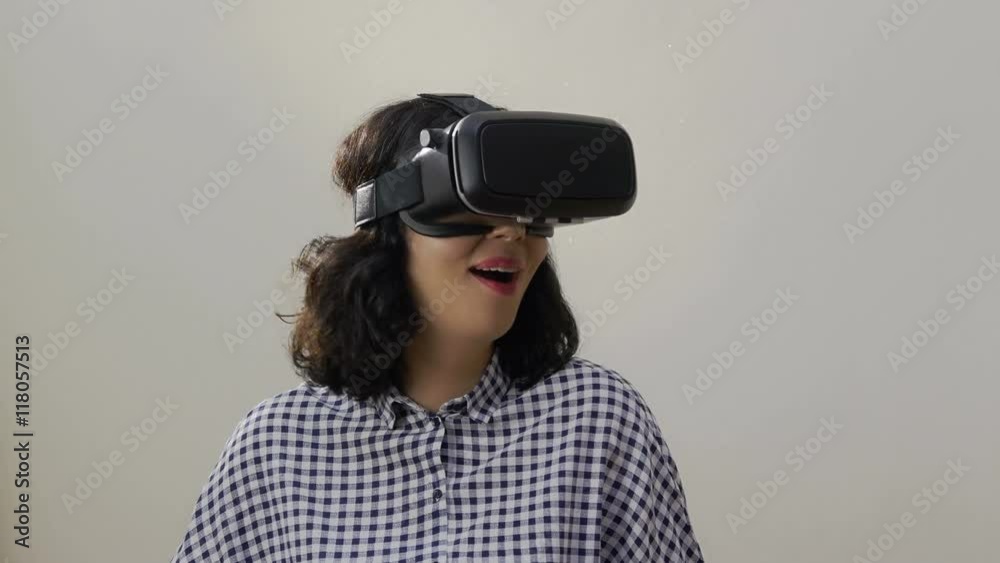Woman uses a head mounted display. A woman in a virtual reality mask looks around.
Woman uses a head mounted display. A woman in a virtual reality mask looks around.
