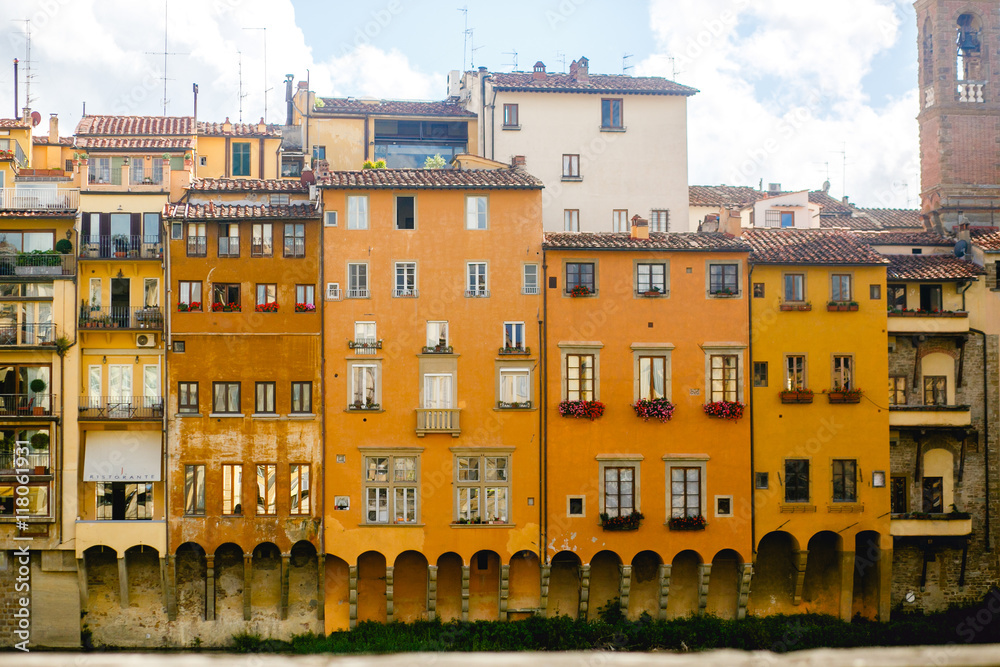 Old yellow buildings hang over the river