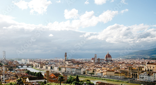 Florence looks gorgeous while white clouds fly over it in a sunn photo