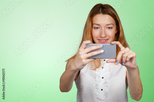 Close up portrait of a young fashionable woman holding a smartphone