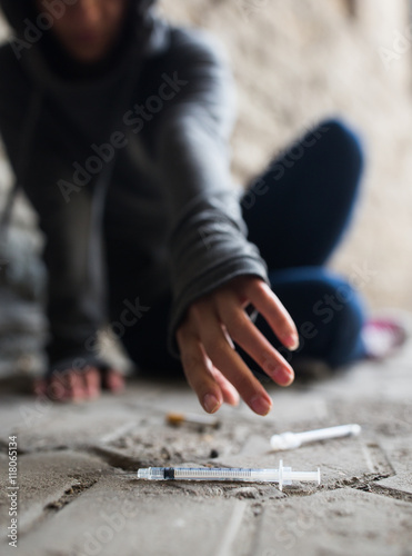close up of addict woman reaching to drug syringes