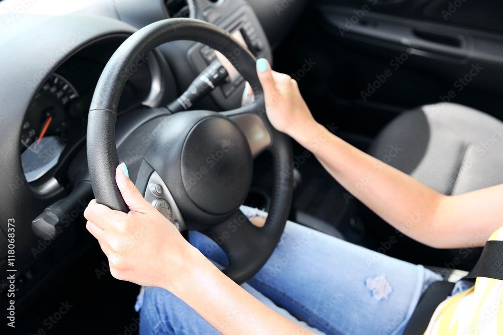 Female hands on steering wheel