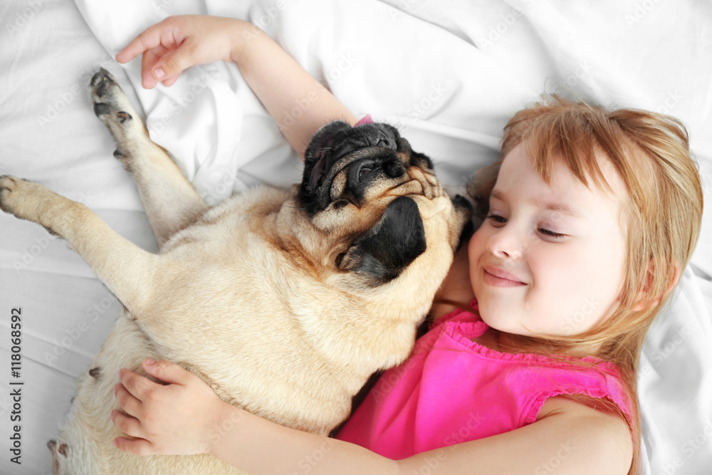 Beautiful girl and cute pug on bed Beautiful girl and cute pug on bed