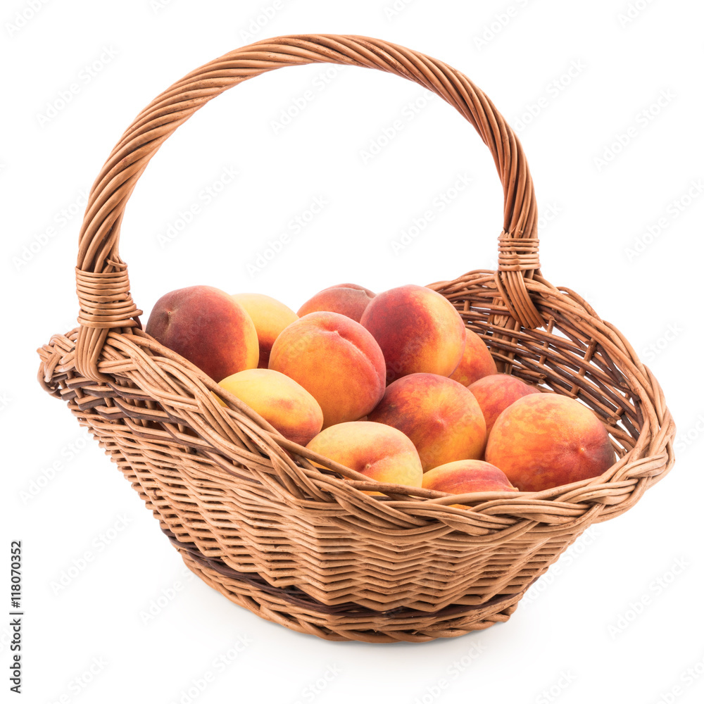 Basket full of fresh peaches isolated on white background.