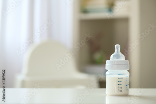 Obraz na płótnie Baby milk formula in small bottle on blurred background