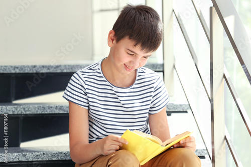 Cute boy reading book on li...