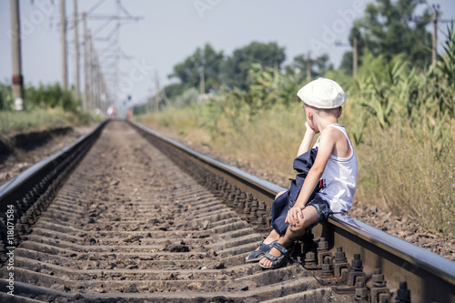a boy with a backpack traveling by rail
