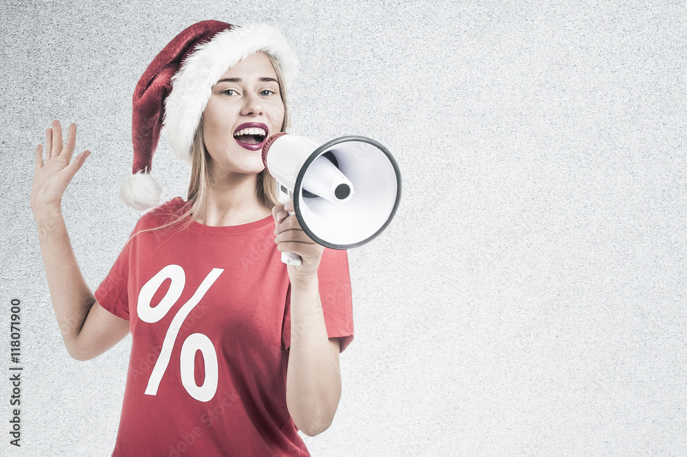 Woman wearing a Santa Claus hat and wearing a red t shirt holding a megaphone Woman wearing a Santa Claus hat and wearing a red t shirt holding a megaphone
