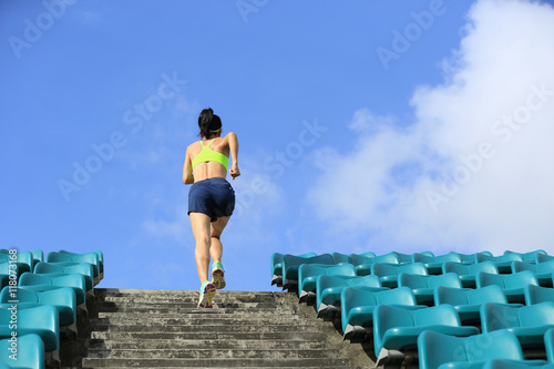 Runner athlete running on stairs. woman fitness jogging workout wellness concept.