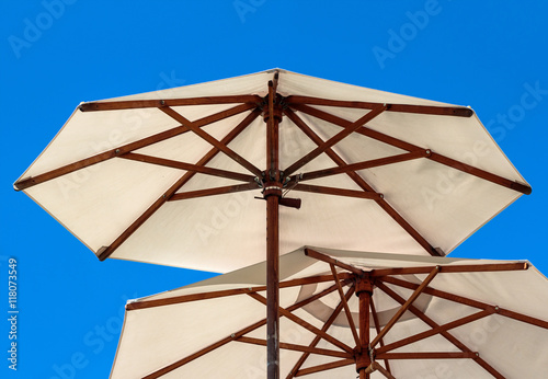 Open wooden construction parasols, blue sky background