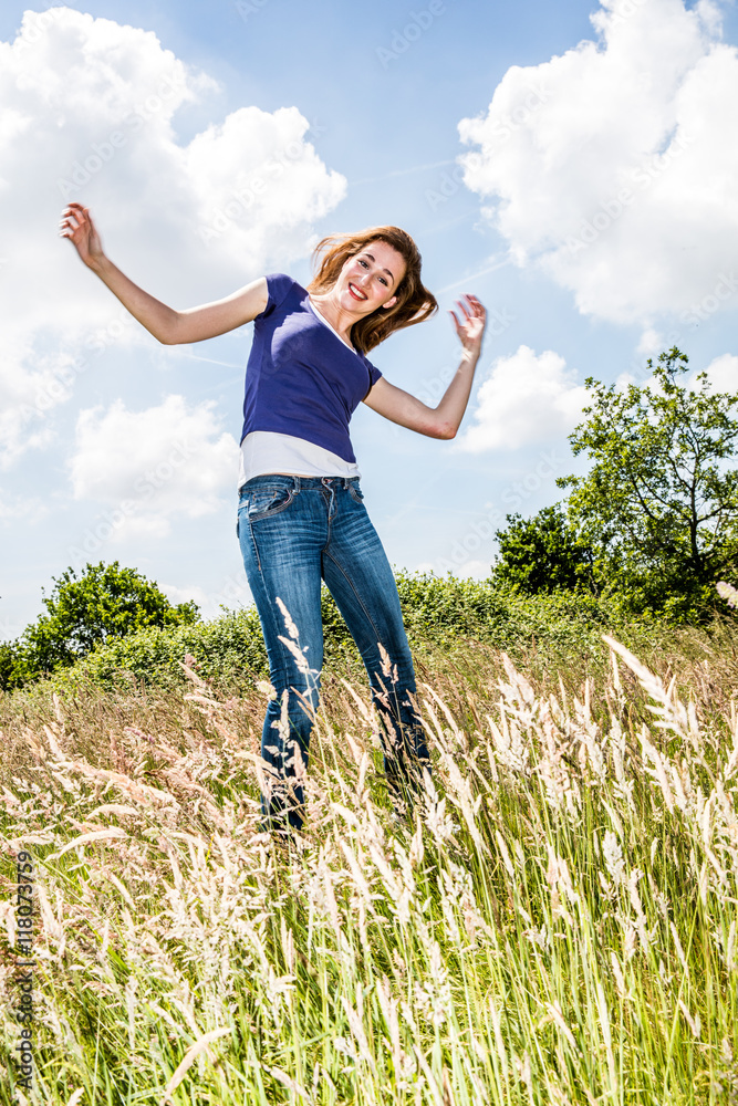 joyful beautiful young girl jumping, dancing in high dry grass joyful beautiful young girl jumping, dancing in high dry grass