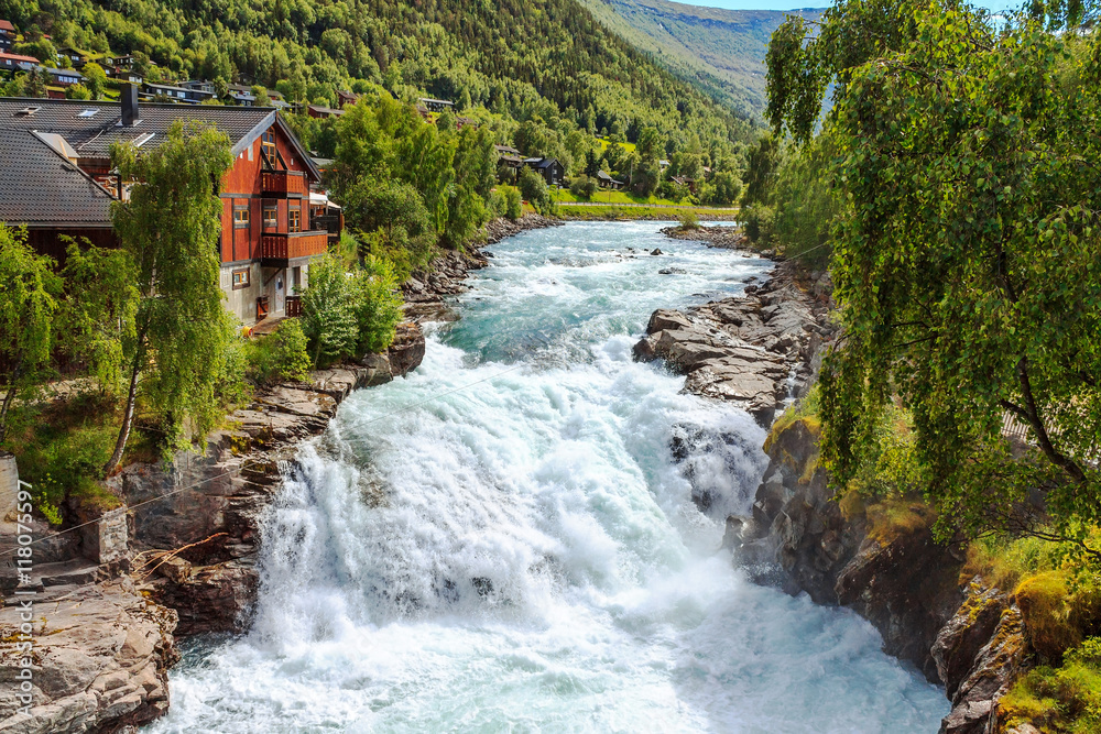 Obraz premium Waterfall and house in Lom, Norway