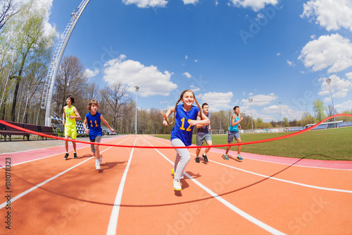 Young sprinters running to the finish line photo