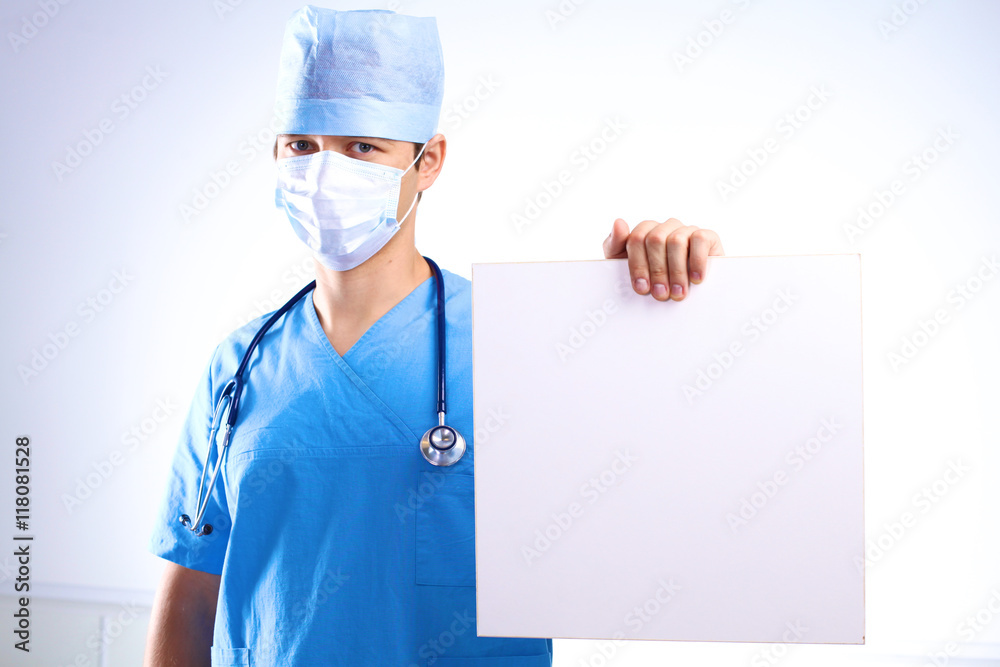surgeon in the mask holds a placard surgeon in the mask holds a placard