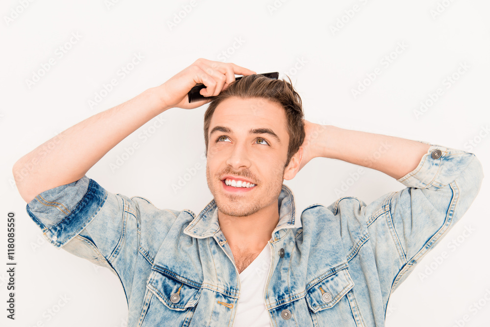 Portrait of handsome young guy combing his hair Portrait of handsome young guy combing his hair