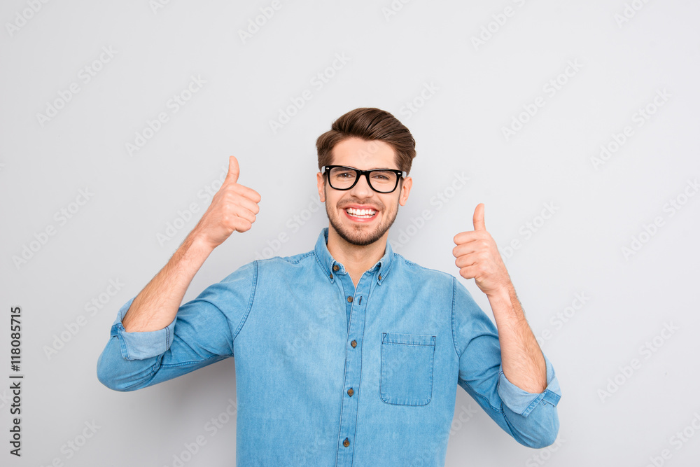 Fototapeta premium Happy smiling man in glasses showing thumbs up