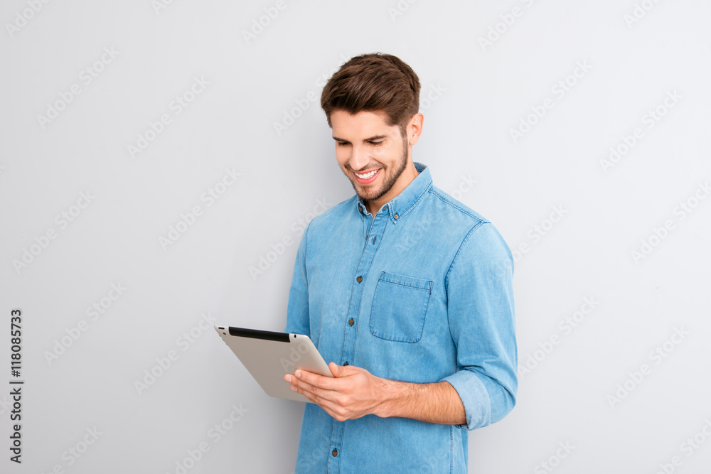 Handsome man using digital tablet on gray background Handsome man using digital tablet on gray background