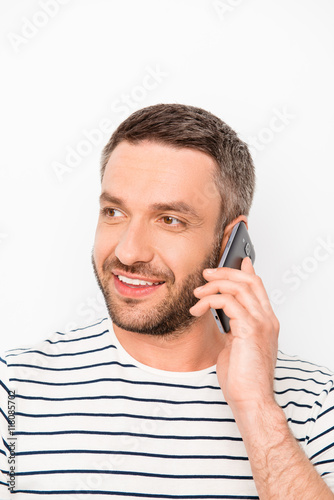 Portrait of happy bearded man having conversation on mobile phon