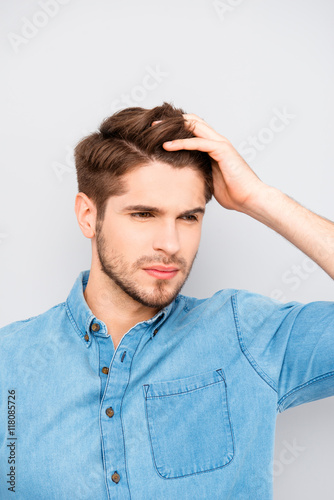 Handsome man touching his hair isolated on gray background