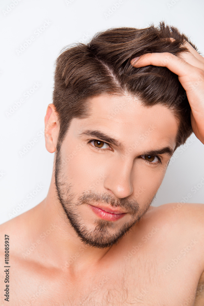Obraz premium Portrait of handsome bearded man combining his hair