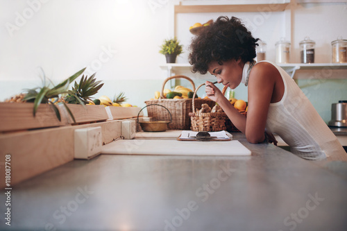 фотографія Proprietor of a juice bar calculating a her business expenses