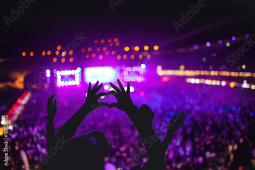 heart shaped hands showing love at festival. Silhouette against concert Lights background