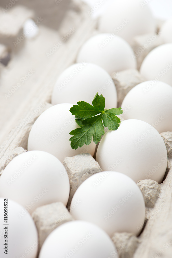a dozen fresh, free range, organic eggs in carton with italian parsley. selective focus, close up, vertical a dozen fresh, free range, organic eggs in carton with italian parsley. selective focus, close up, vertical