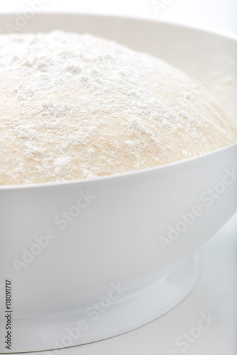 fresh, handmade, uncooked pizza or bread dough in a white bowl