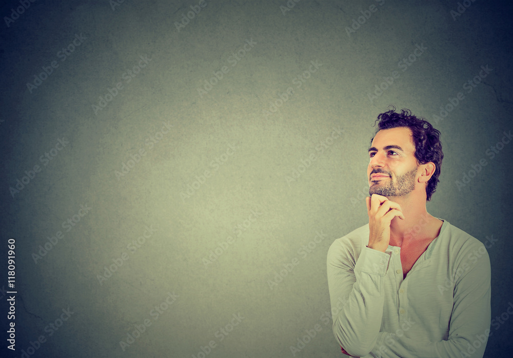 Happy young man thinking daydreaming looking up Happy young man thinking daydreaming looking up