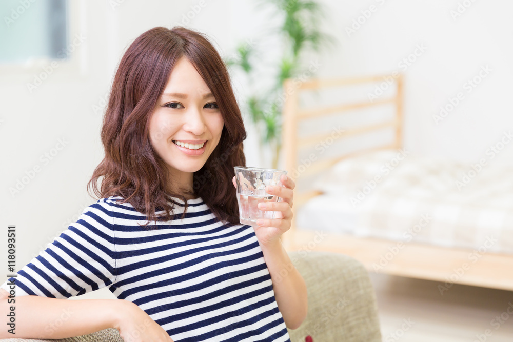 部屋で水を飲む女性 部屋で水を飲む女性