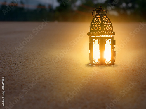 lighting with candle inside Lantern shining on sand floor playgr photo