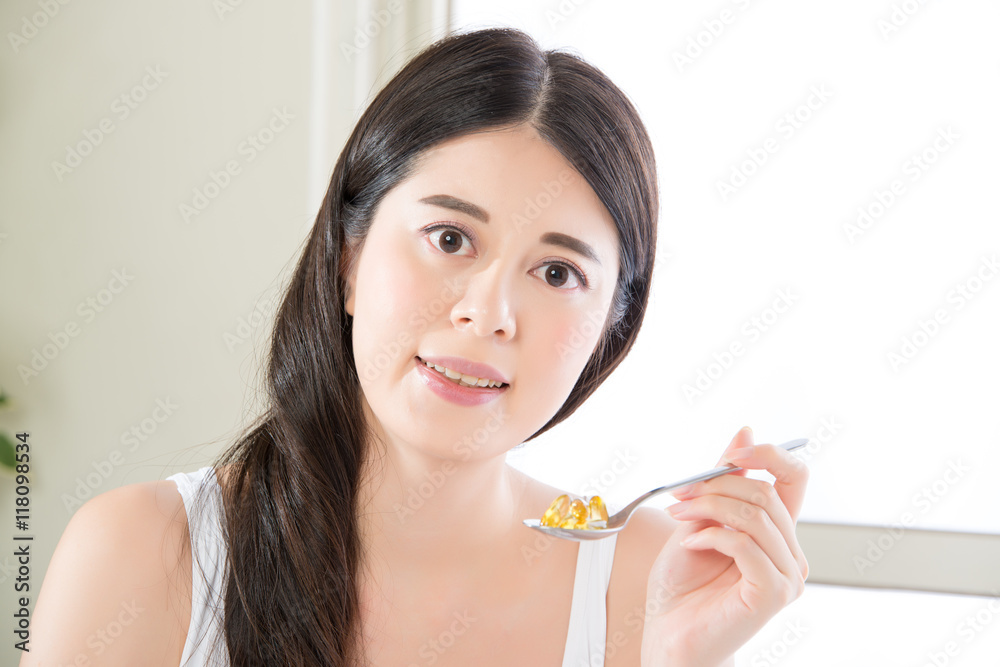 young beautiful asian woman eating nutritional supplement pill f young beautiful asian woman eating nutritional supplement pill f