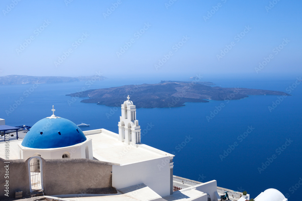 The Three bells of Fira and blue dome, Santorini, Greece with Santorini's volcano in the background