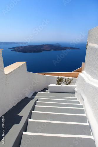 Famous white and grey stairs of Santorini with Volcano the background