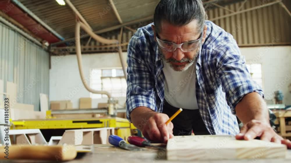 Facing view of carpenter focused while working Facing view of carpenter focused while working