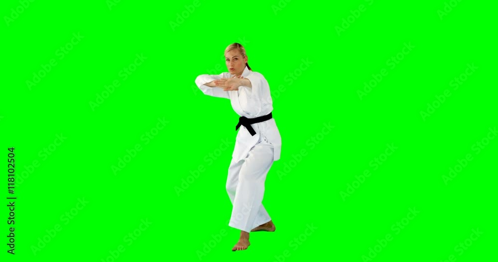 Woman doing judo on a green background Woman doing judo on a green background